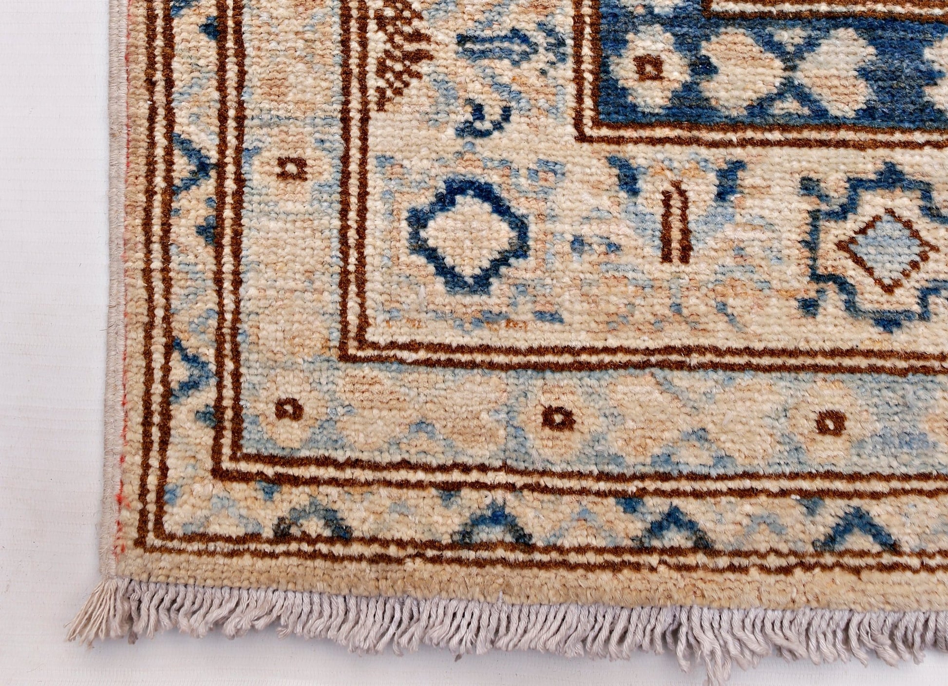 A handmade Afghan Super Kazakh runner featuring traditional blue and brown geometric motifs.