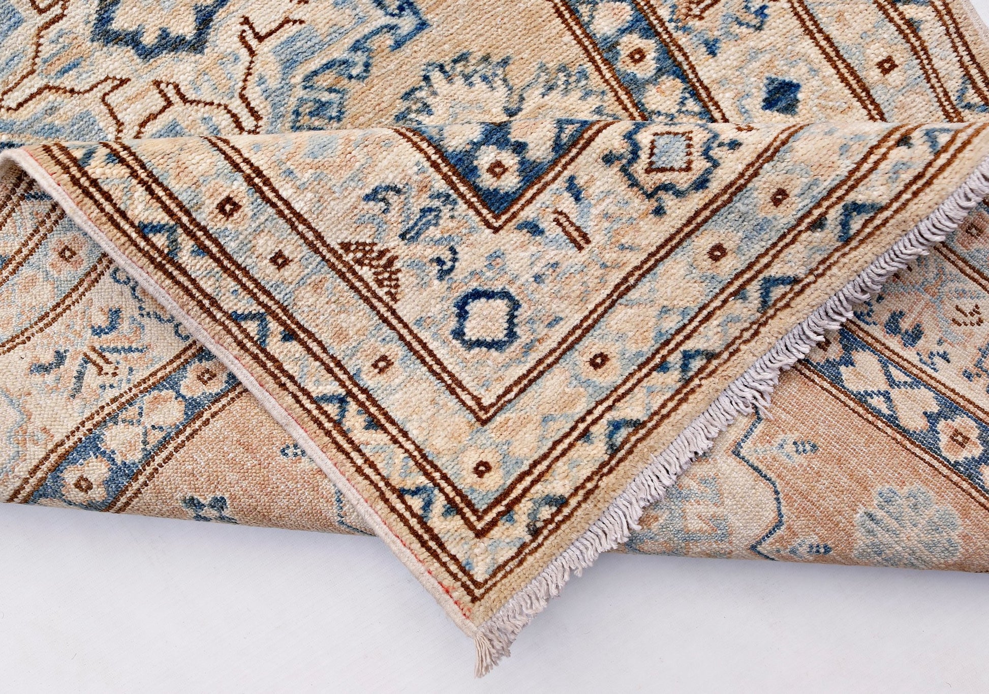 A handmade Afghan Super Kazakh runner featuring traditional blue and brown geometric motifs.