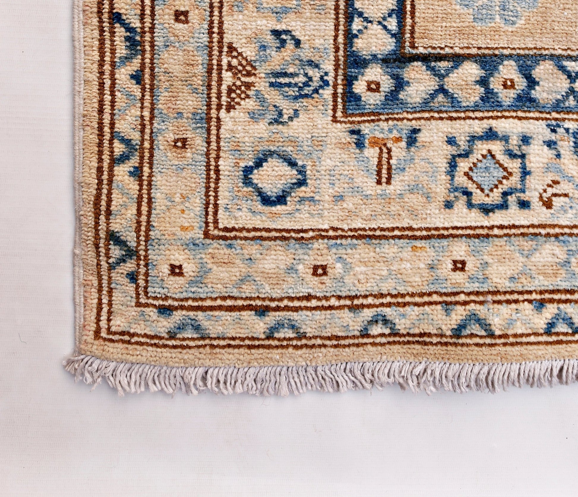 A handmade Afghan Super Kazakh runner featuring traditional blue and brown geometric motifs.