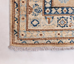 A handmade Afghan Super Kazakh runner featuring traditional blue and brown geometric motifs.