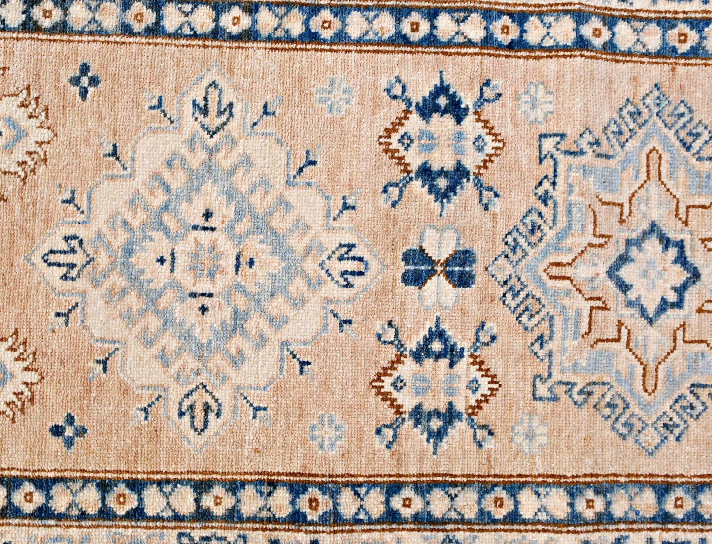 A handmade Afghan Super Kazakh runner featuring traditional geometric motifs in blue and beige.