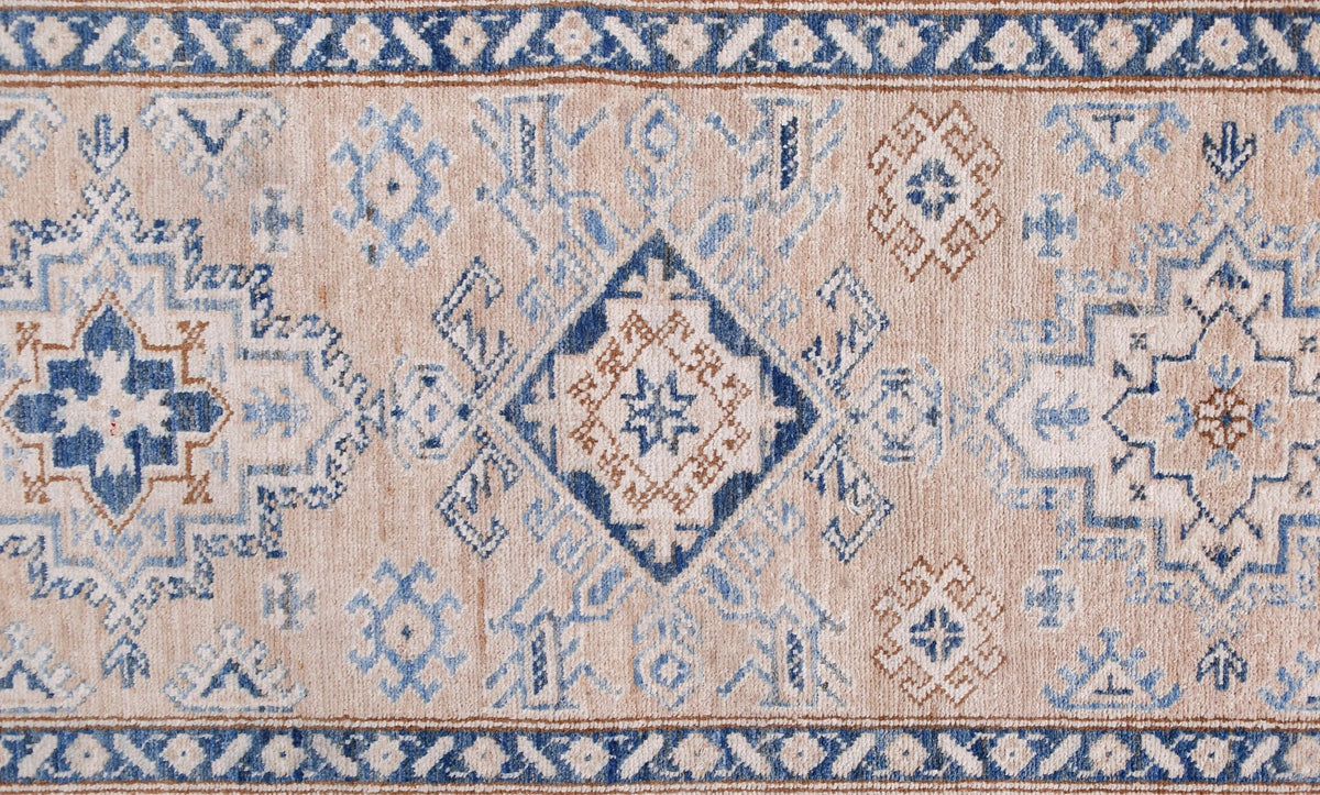 An Afghan Super Kazakh runner featuring traditional geometric motifs in blue and tan wool.