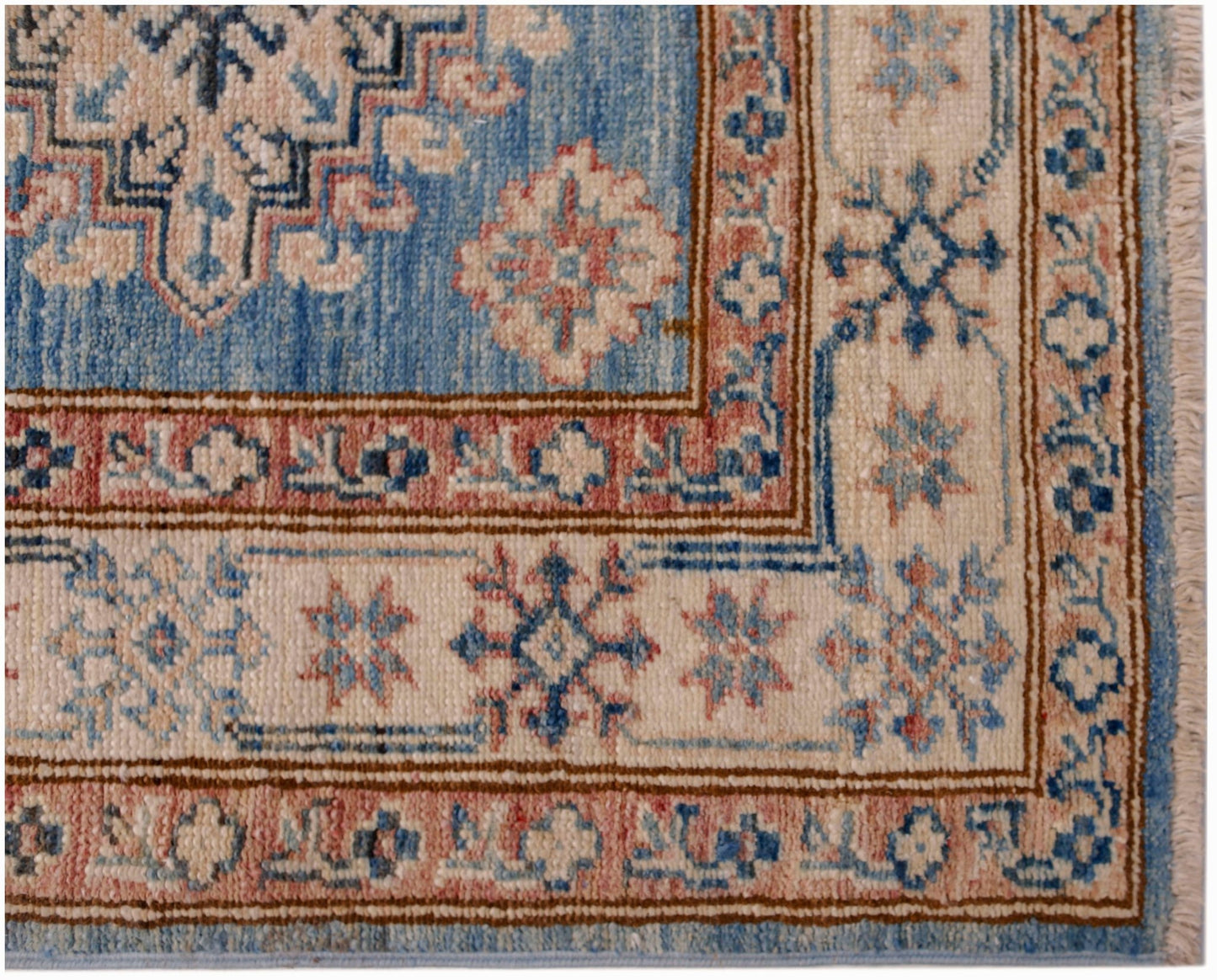 A handmade Afghan Super Kazakh runner featuring traditional blue, cream, and pink geometric motifs.