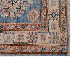 A handmade Afghan Super Kazakh runner featuring traditional blue, cream, and pink geometric motifs.