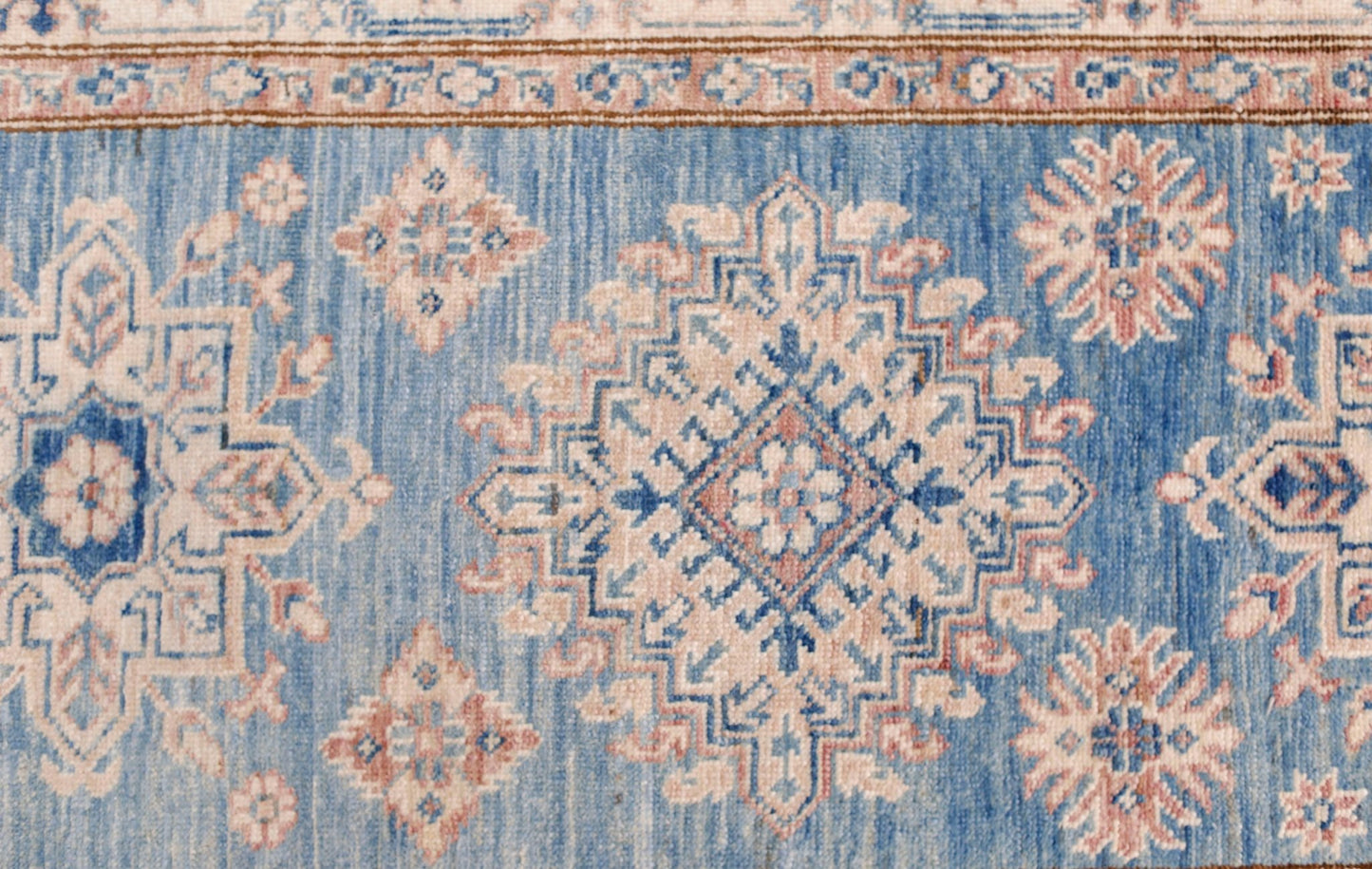 An Afghan Super Kazakh runner featuring traditional geometric motifs in blue, cream, and pink.