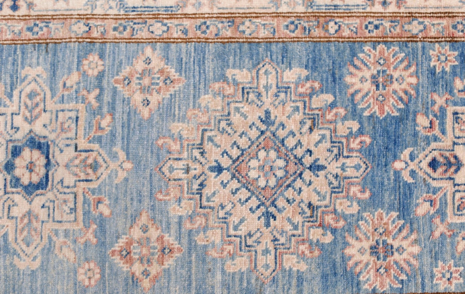 An Afghan Super Kazakh runner featuring traditional geometric motifs in blue, cream, and pink.