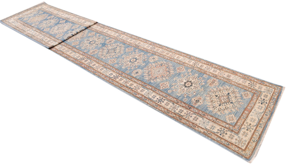 A long, handmade Afghan Super Kazakh runner rug featuring traditional blue and beige geometric motifs.
