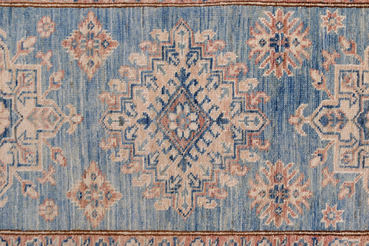 An Afghan Super Kazakh runner featuring traditional geometric motifs in blue, cream, and pink.