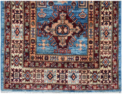 An Afghan Super Kazakh runner rug featuring a blue field with a central geometric medallion.