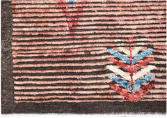 Hand-knotted Afghan rug with horizontal pink stripes and a colorful geometric leaf motif.