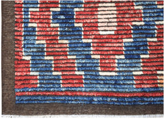 A hand-knotted Afghan rug featuring a geometric pattern in red, blue, and cream wool.