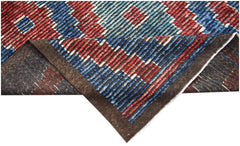 An Afghan Yekta rug with a geometric pattern in red and blue, shown folded to reveal its backing.