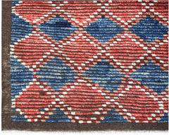 Hand-knotted Afghan rug featuring a geometric pattern in red, blue, and white wool.