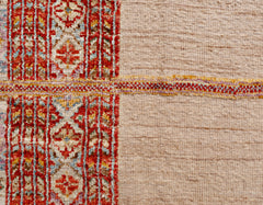 An Afghan Yekta rug featuring a textured beige field contrasted by a vibrant red patterned border.
