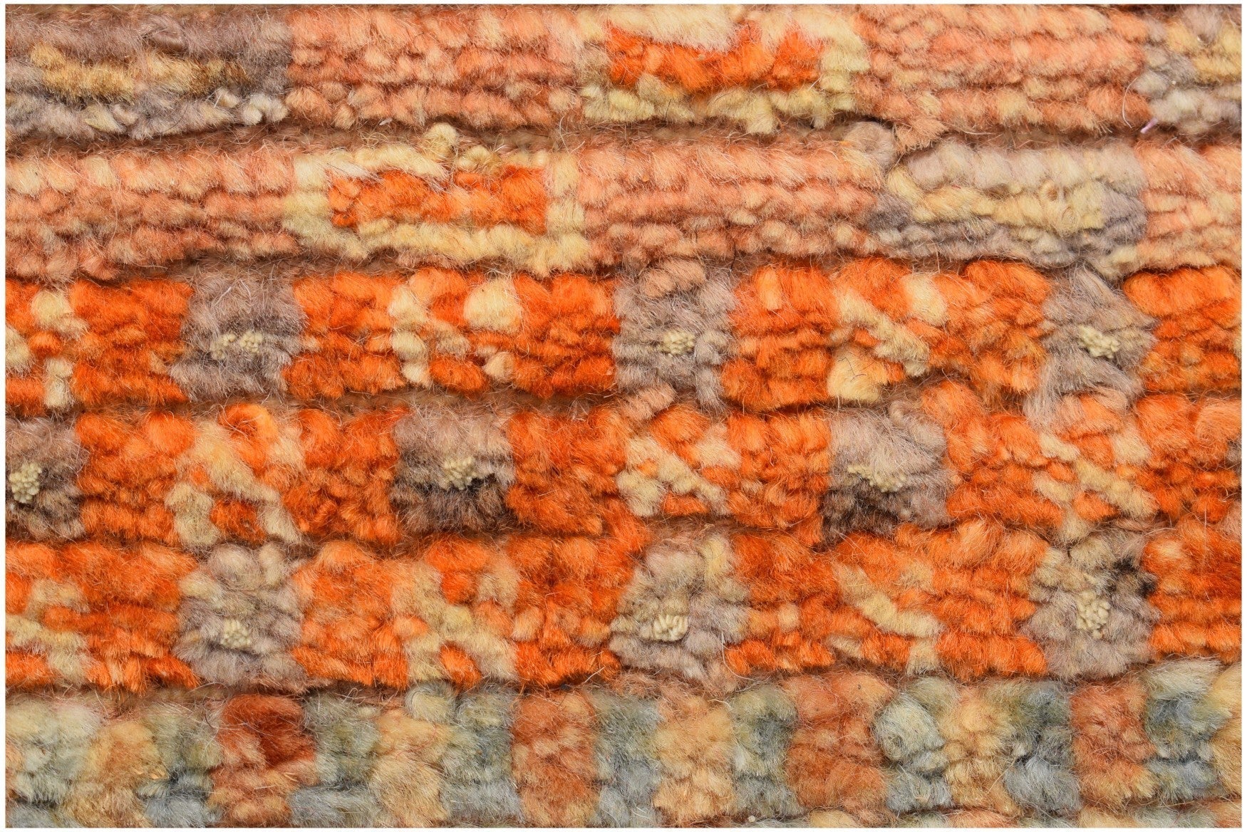 A close-up of an Afghan Yekta rug featuring a textured, hand-knotted pattern in shades of orange.