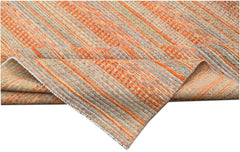A handmade Afghan Yekta rug featuring a textured, striped pattern in shades of orange and blue.