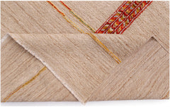 A folded Afghan Yekta rug featuring a textured beige wool surface with colorful linear accents.