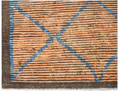 An Afghan Yekta rug featuring a geometric blue diamond pattern on a textured orange field.