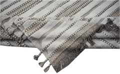 A handmade Afghan Yekta rug featuring a textured striped pattern in neutral tones with fringe.