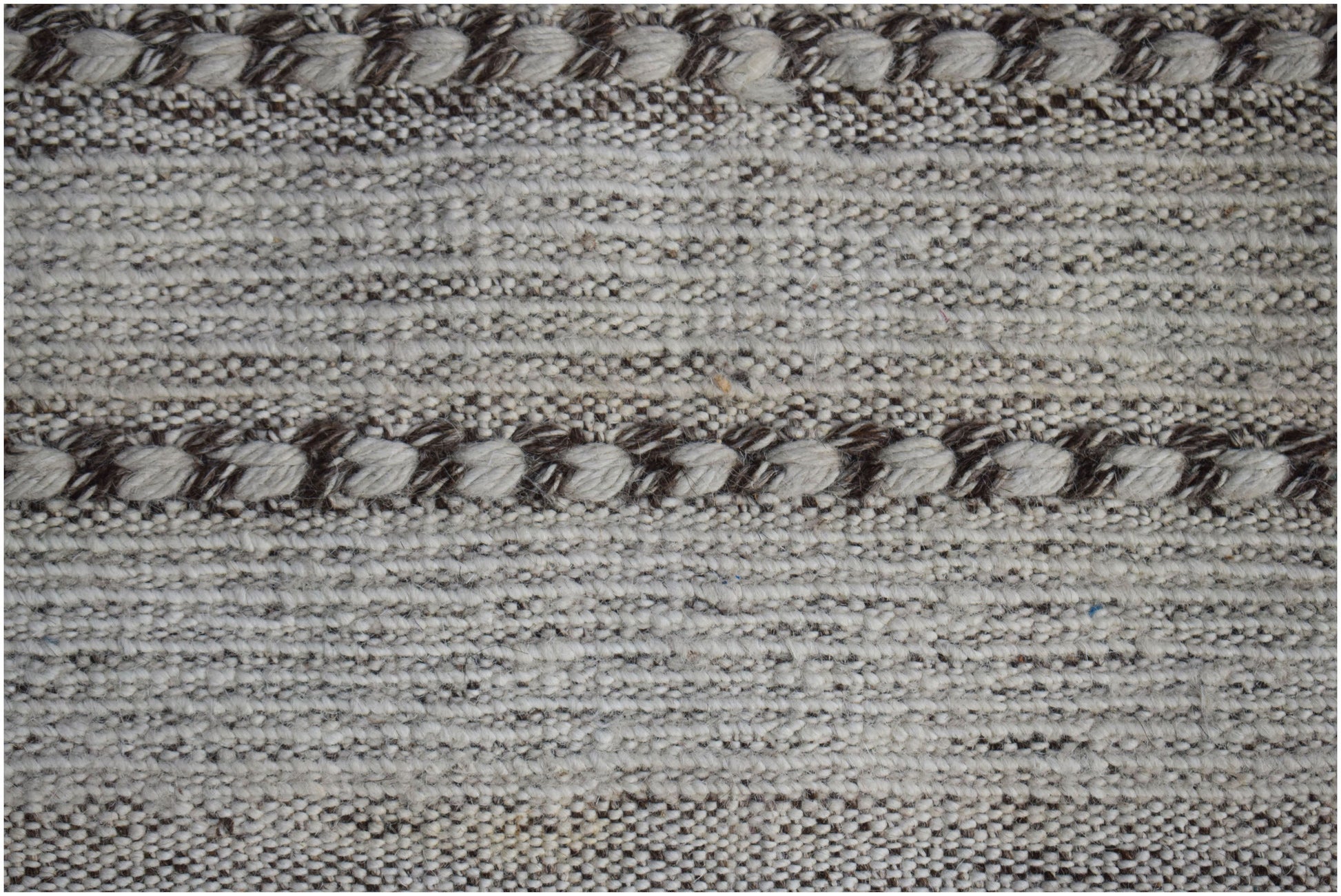 A handmade Afghan Yekta rug featuring a textured pattern of alternating cream and brown wool stripes.