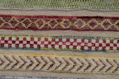 A close-up of an Afghan Yekta runner featuring horizontal bands of geometric and checkered patterns.