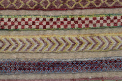 A handmade Afghan Yekta runner featuring horizontal bands of geometric and checkered patterns.