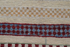 A close-up of an Afghan Yekta runner featuring horizontal bands of cream, gold, and red patterns.