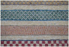 A handmade Afghan runner featuring horizontal stripes of textured wool in green, orange, and red.