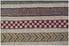 A handmade Afghan runner featuring horizontal bands of geometric patterns in red, green, and tan.