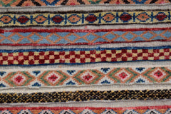 A close-up of an Afghan Yekta runner featuring horizontal bands of intricate geometric patterns.