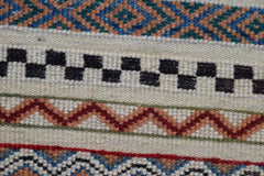 A close-up of an Afghan Yekta runner featuring geometric patterns in blue, orange, and black wool.