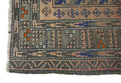 A corner detail of an antique Afghan Balouch rug featuring geometric patterns in wool.