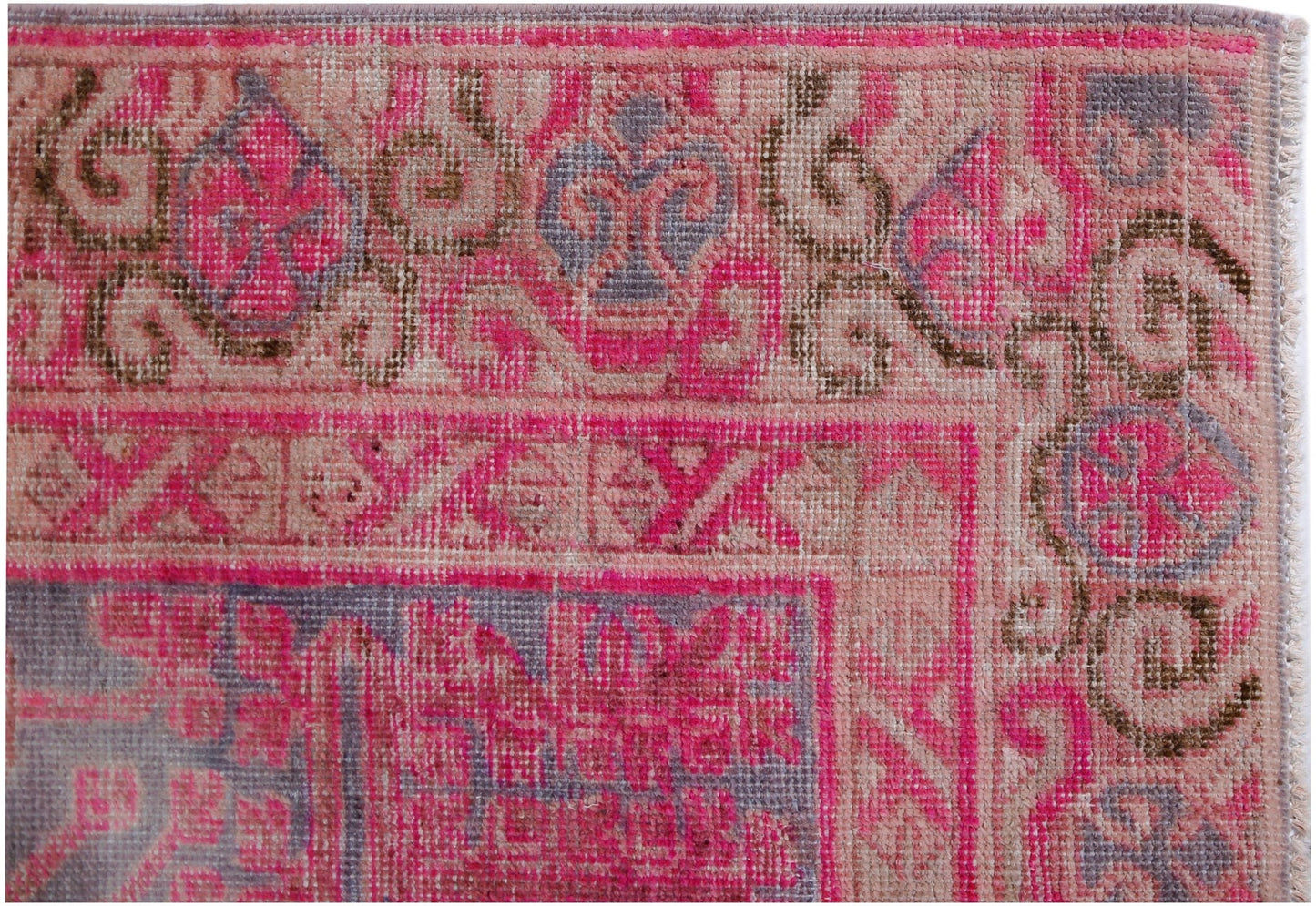 An antique handwoven Khotan rug featuring an intricate pomegranate pattern in vibrant pink tones.