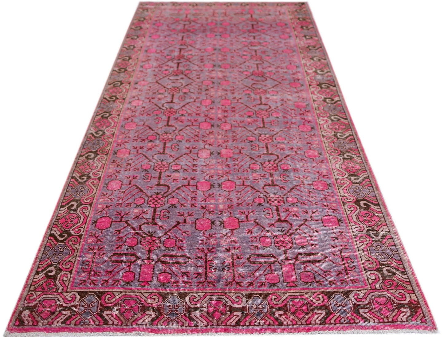 An antique handwoven Khotan runner rug featuring an intricate pomegranate pattern in vibrant pink.