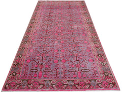 An antique handwoven Khotan runner rug featuring an intricate pomegranate pattern in vibrant pink.