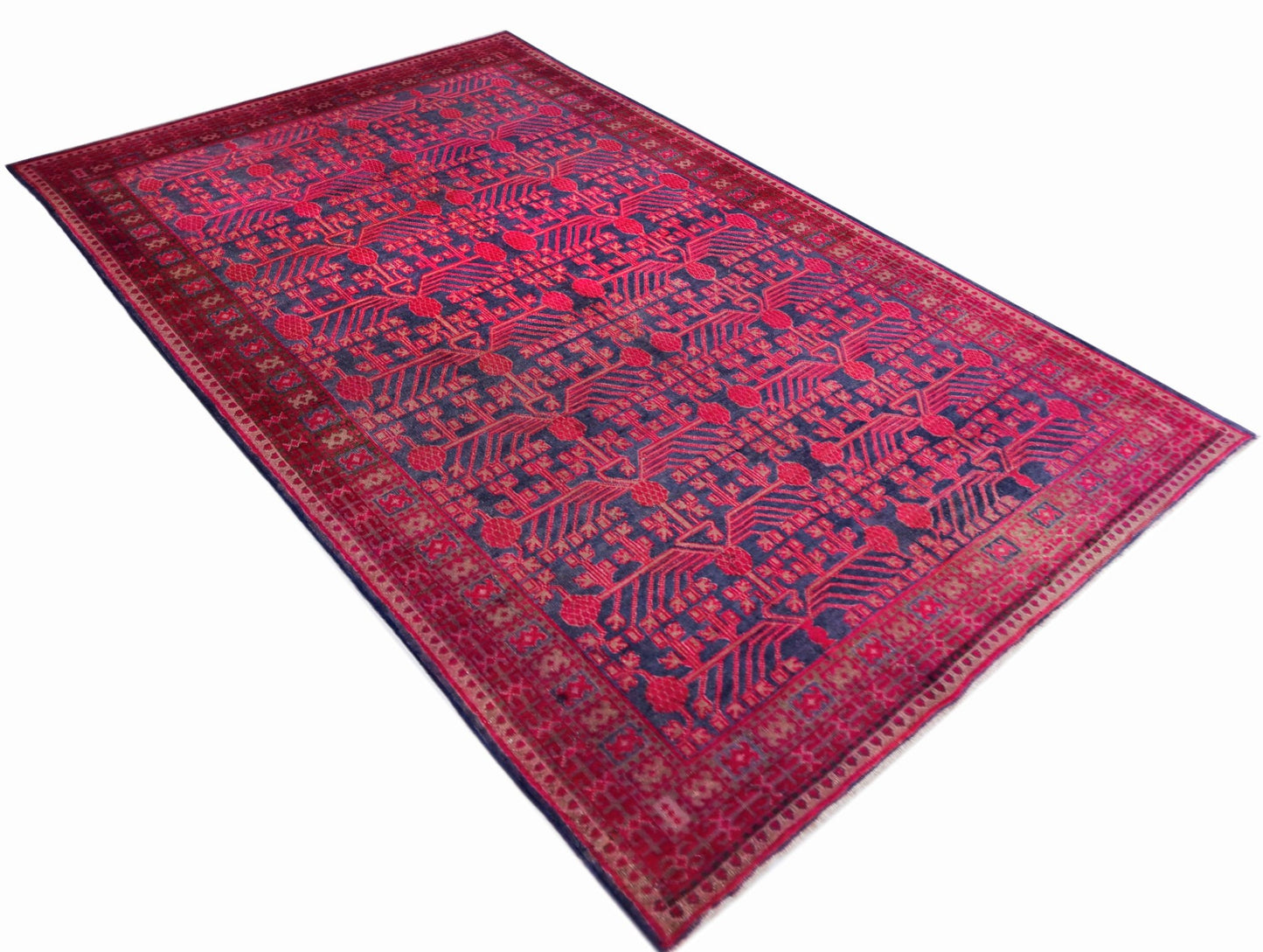 An antique handwoven Khotan rug featuring an intricate pomegranate pattern in vibrant pink tones.