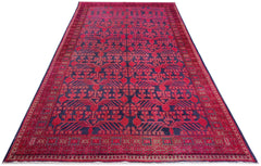 An antique handwoven Khotan rug featuring an intricate pomegranate pattern in vibrant pink.