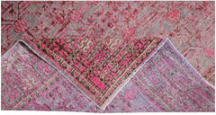 An antique handwoven Khotan rug featuring an intricate pomegranate pattern in vibrant pink tones.