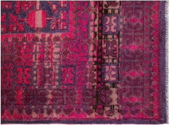 An antique handwoven Khotan rug featuring an intricate pomegranate pattern in vibrant pink tones.