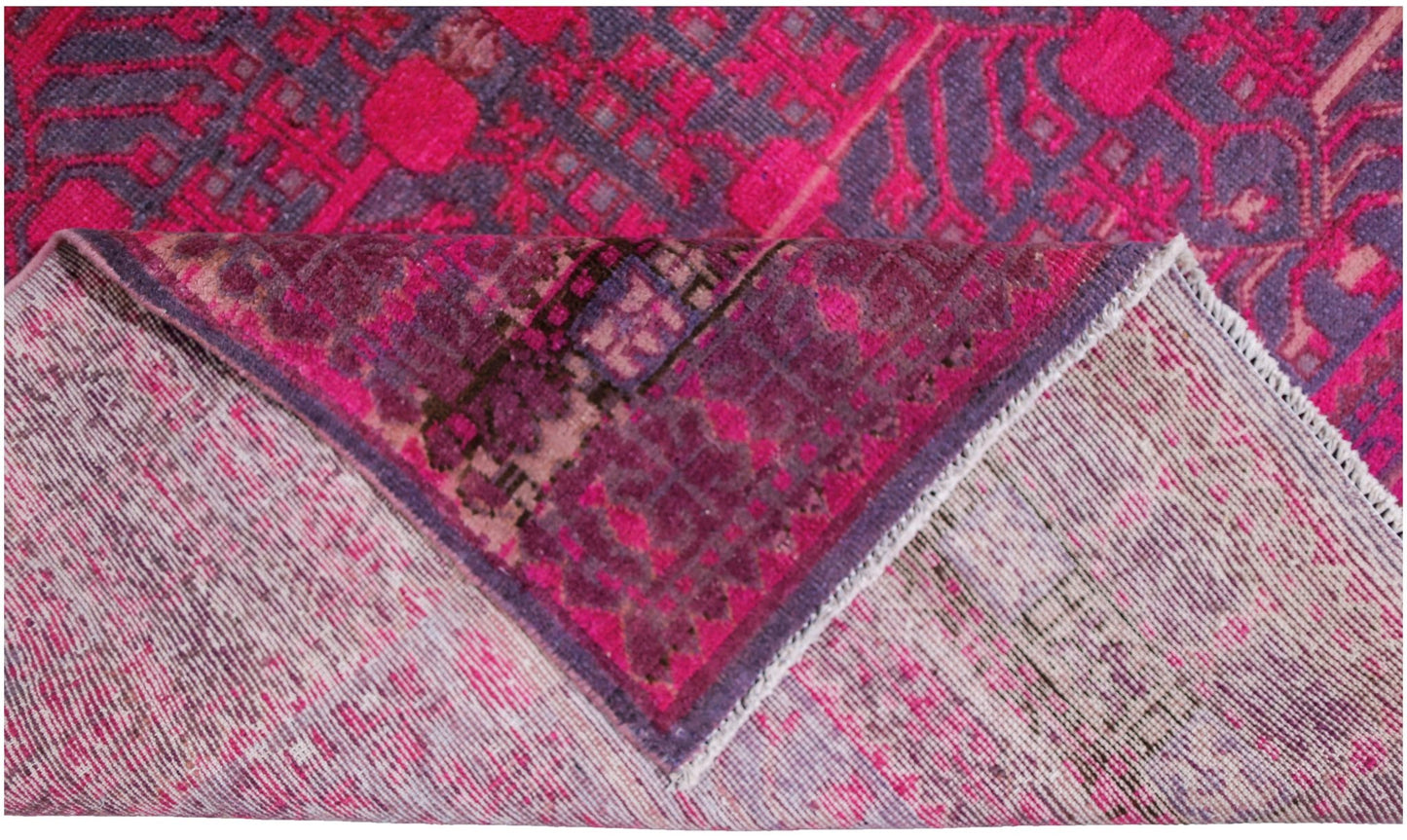 An antique handwoven Khotan rug featuring an intricate pomegranate pattern in vibrant pink.