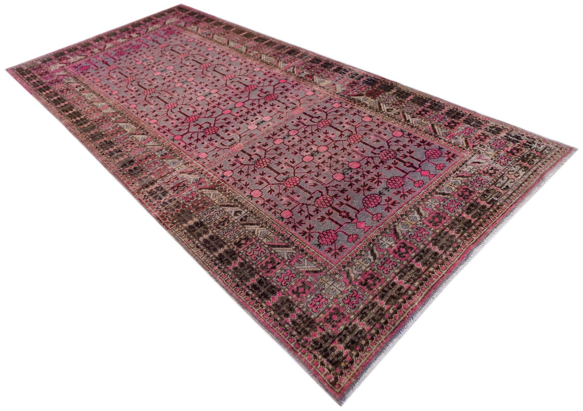An antique handwoven Khotan rug featuring an intricate pomegranate pattern in vibrant pink tones.