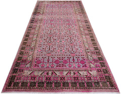 An antique handwoven Chinese Khotan rug featuring a pink pomegranate pattern on a grey field.