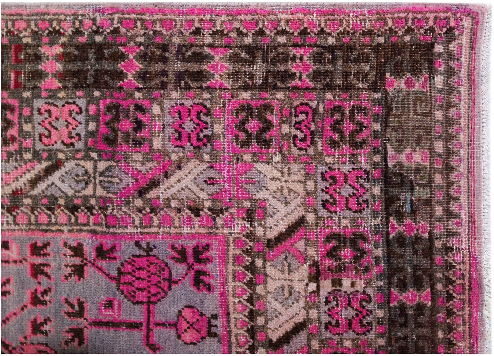 An antique handwoven Khotan rug featuring an intricate pomegranate pattern in vibrant pink.