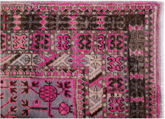 An antique handwoven Khotan rug featuring an intricate pomegranate pattern in vibrant pink.
