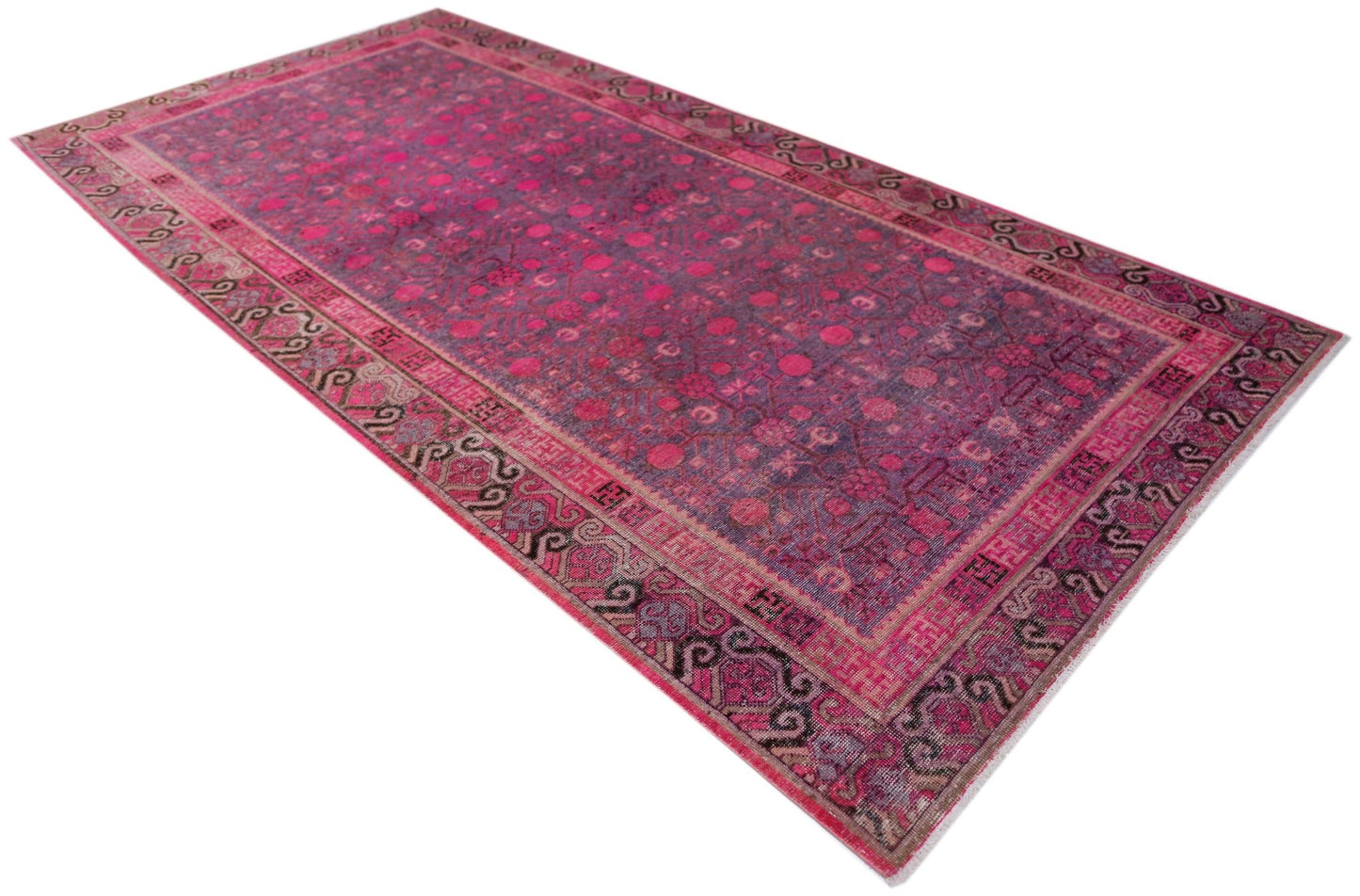 An antique handwoven Khotan rug featuring an intricate pomegranate pattern in vibrant pink tones.
