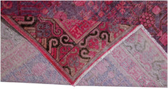 An antique handwoven Khotan rug featuring an intricate pomegranate pattern in vibrant pink.