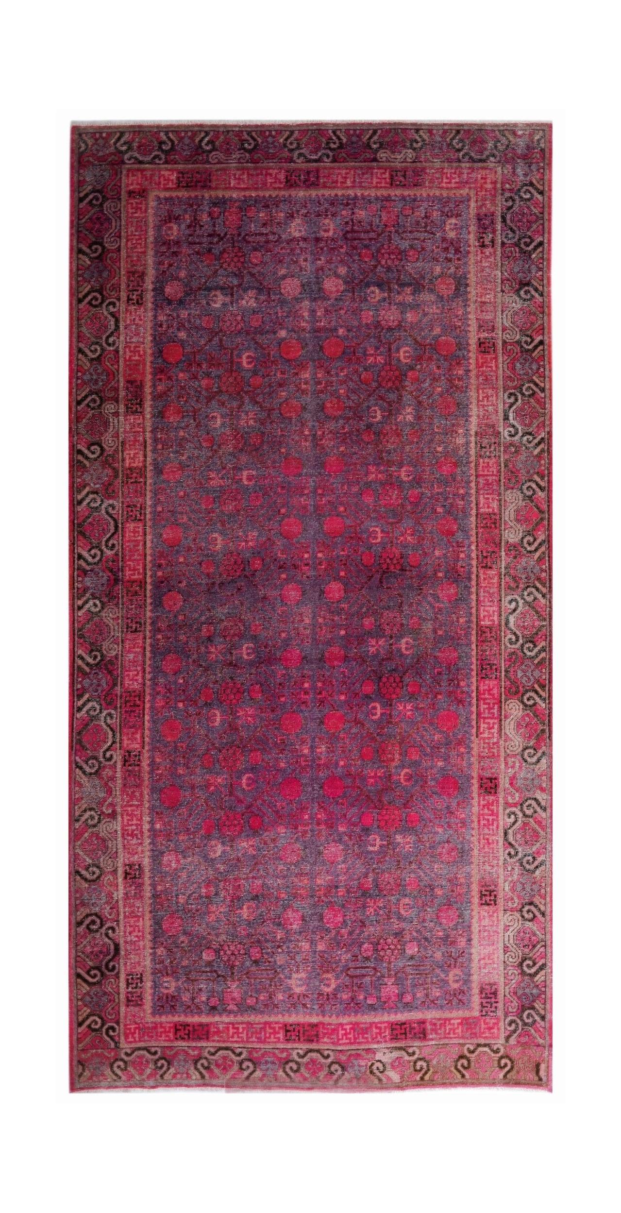 An antique handwoven Khotan rug featuring a vibrant pink pomegranate pattern on a wool base.