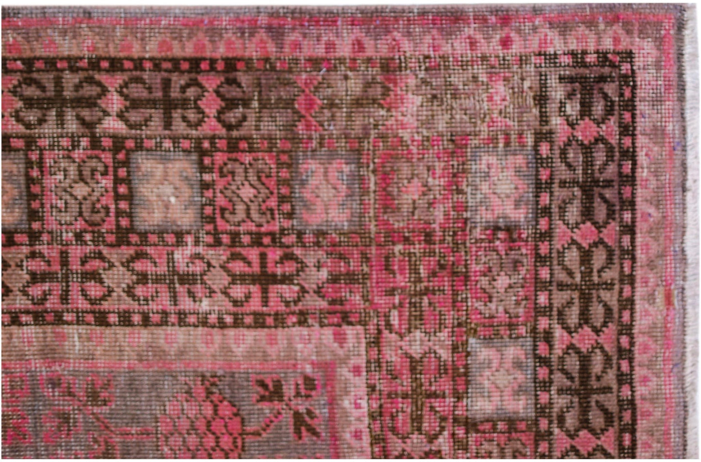An antique handwoven Khotan rug featuring an intricate pomegranate pattern in shades of pink.