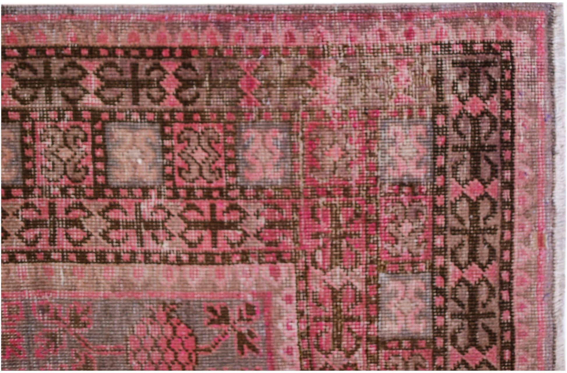 An antique handwoven Khotan rug featuring an intricate pomegranate pattern in shades of pink.