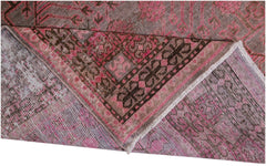 An antique handwoven Khotan rug featuring an intricate pomegranate pattern in vibrant pink tones.
